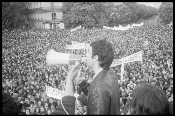 Photo d'un homme parlant dans un mégaphone au milieu d'une vaste manifestation