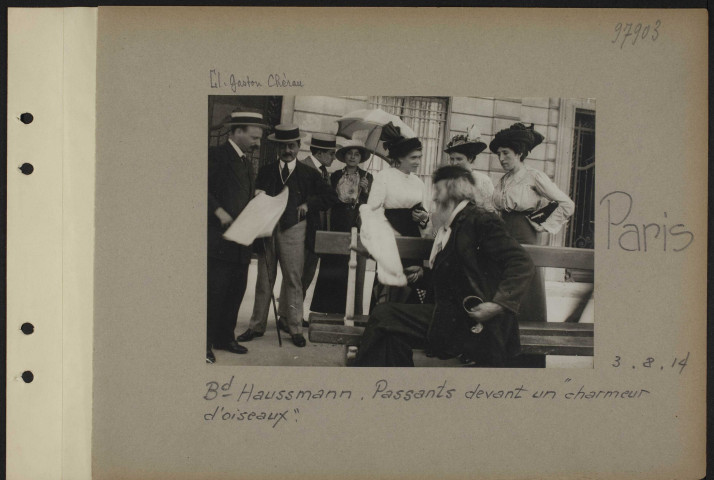 Paris. Boulevard Haussmann. Passants devant un "charmeur d'oiseaux"