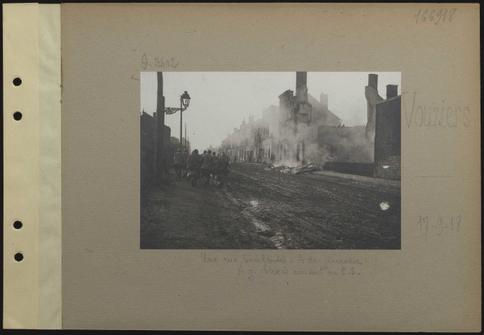 Vouziers. Une rue bombardée. À droite, incendie. À gauche, blessés arrivant au poste de secours