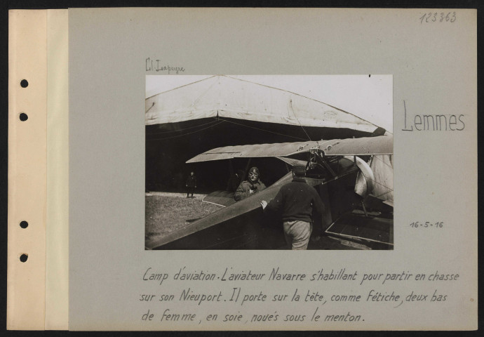Lemmes. Camp d'aviation. L'aviateur Navarre s'habillant pour partir en chasse sur son Nieuport. Il porte sur la tête, comme fétiche, deux bas de femme, en soie, noués sous le menton