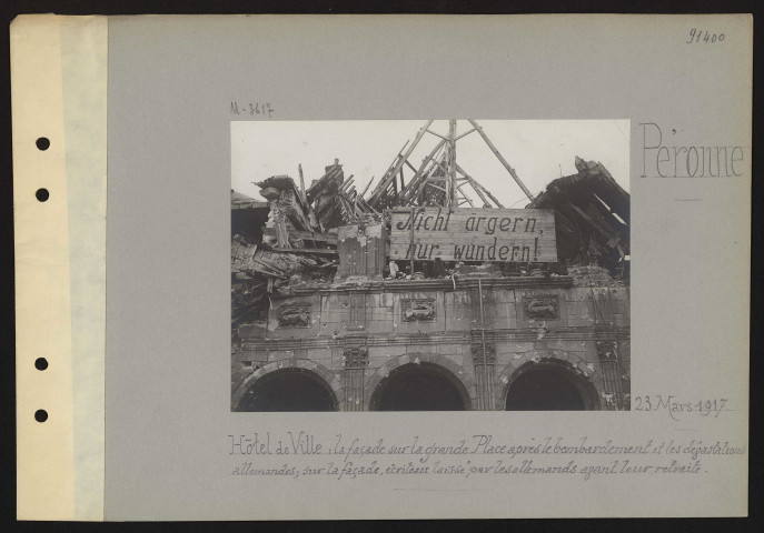 Péronne. Hôtel de ville : la façade sur la grande place après le bombardement et les dévastations allemandes ; sur la façade, écriteau laissé par les Allemands avant leur retraite