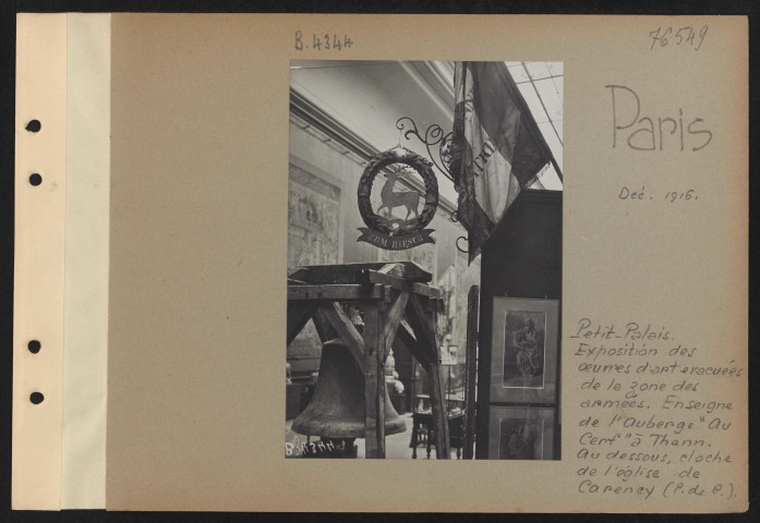 Paris. Petit Palais. Exposition des œuvres d'art évacuées de la zone des armées. Enseigne de l'auberge "Au cerf" à Thann. Au-dessous, cloche de l'église de Careney (Pas-de-Calais)