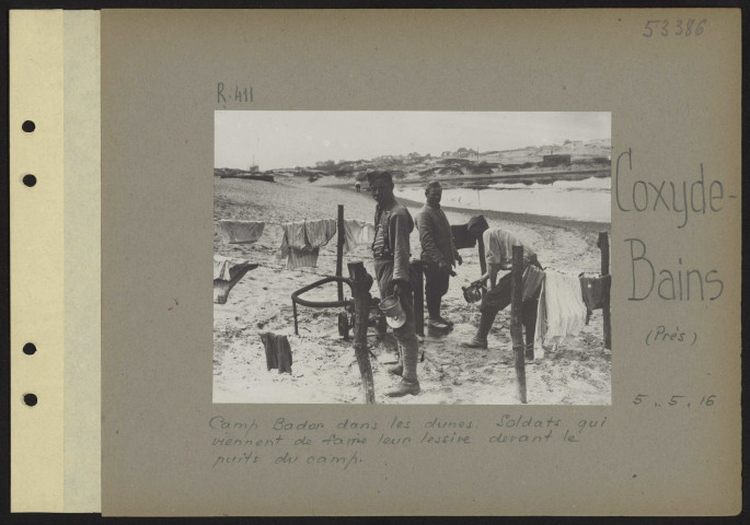 Coxyde-Bains (près). Camp Bador dans les dunes. Soldats qui viennent de faire leur lessive devant le puits du camp