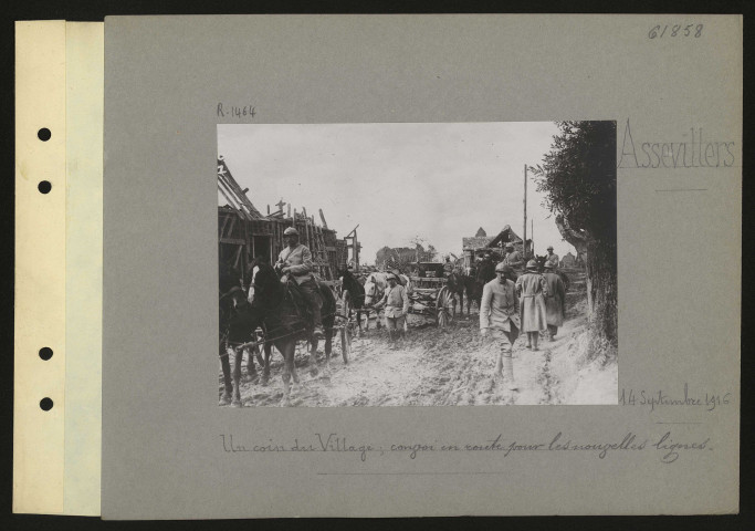 Assevillers. Un coin du village ; convoi en route pour les nouvelles lignes