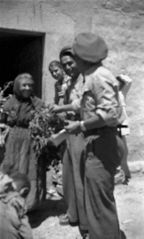 Brigadistes et une femme devant l'entrée de l'infirmerie du 1er bataillon dans une cabane près de Fayon