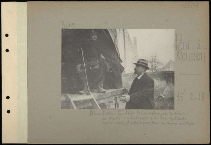 Pont-à-Mousson. Place Duroc. Pendant l'évacuation de la ville. Le maire s'entretenant avec des vieillards qu'on vient d'embarquer dans un camion militaire