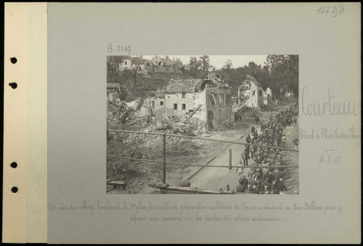 Courteau (près et à l'ouest de Château-Thierry). Un coin du village bombardé. Au premier plan, les sociétés de préparation militaire de France se rendant au Bois Belleau pour y déposer une couronne sur les tombes des soldats américains