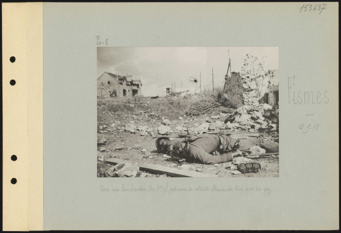 Fismes. Une rue bombardée. Au premier plan, cadavres de soldats allemands tués par les gaz