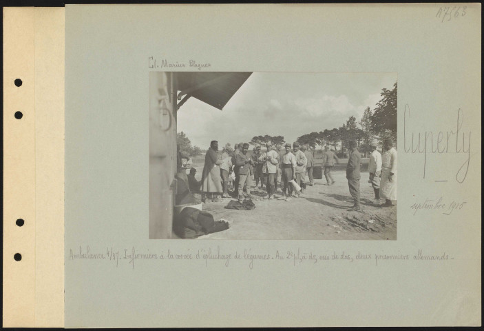 Cuperly. Ambulance 4/37. Infirmiers à la corvée d'épluchage de légumes. Au deuxième plan, à droite, vus de dos, deux prisonniers allemands