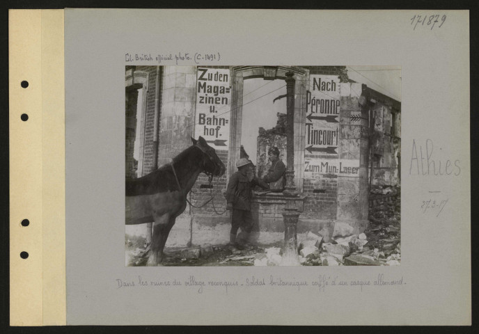 Athies. Dans les ruines du village reconquis. Soldat britannique coiffé d'un casque allemand