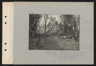 Dives. Destructions systématiques par les Allemands : le château incendié, vue prise du parc ; au premier plan, arbres coupés et réseau de fils de fer barbelés
