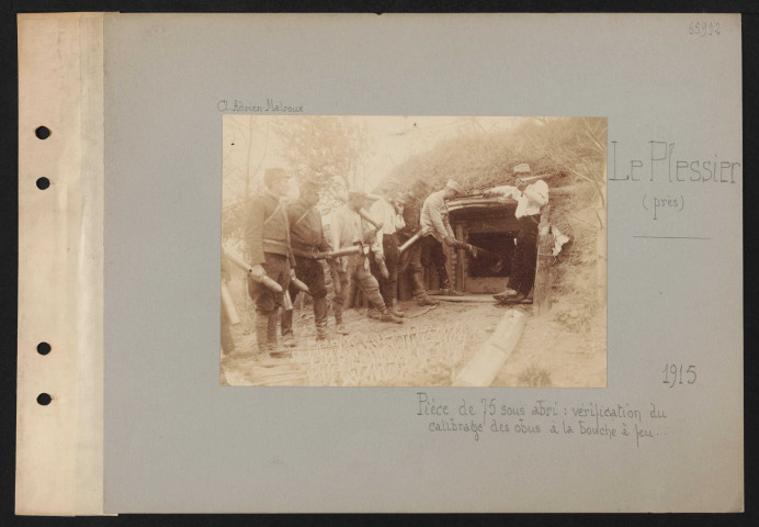 Le Plessier (près). Pièce de 75 sous abri : vérification du calibrage des obus à la bouche à feu …