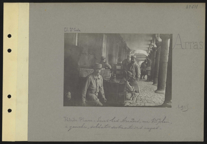 Arras. Petite Place. Sous les arcades ; au premier plan, à gauche, soldats sortant des cages