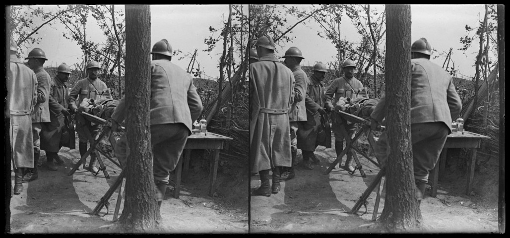 [Soldats français, équipés de casques Adrian, avec un blessé sur un brancard]