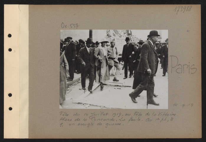 Paris. Fête du 14 juillet 1919, ou fête de la Victoire. Place de la Concorde. La foule. Au premier plan, à gauche, un aveugle de guerre