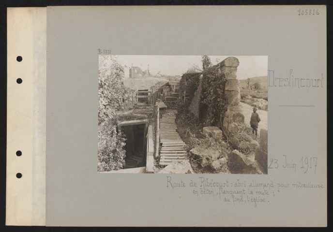Deslincourt. Route de Ribécourt : abri allemand pour mitrailleuse en béton, flaquant la route ; au fond, l'église